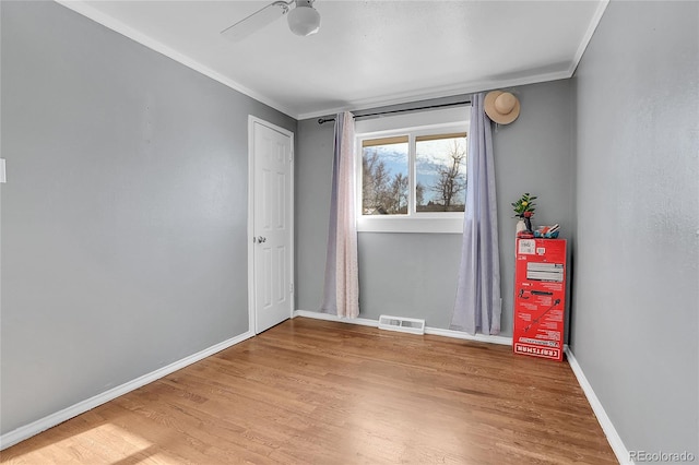 spare room featuring ceiling fan, crown molding, and wood-type flooring