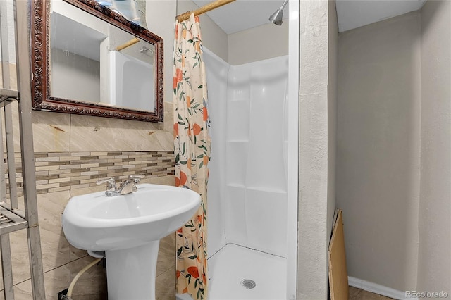 bathroom with sink, walk in shower, and tasteful backsplash