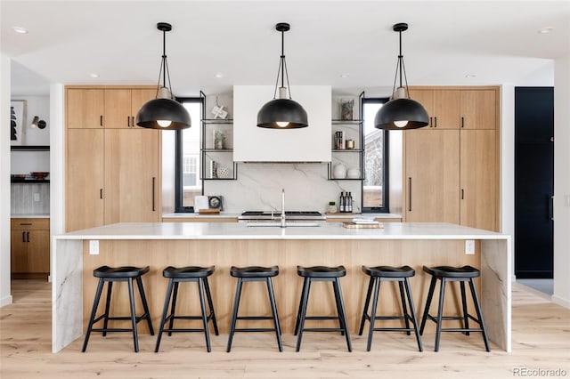 kitchen with pendant lighting, decorative backsplash, and a spacious island