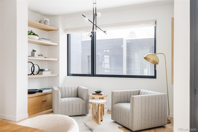 living area featuring built in shelves and hardwood / wood-style floors