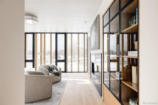 corridor with hardwood / wood-style flooring and expansive windows