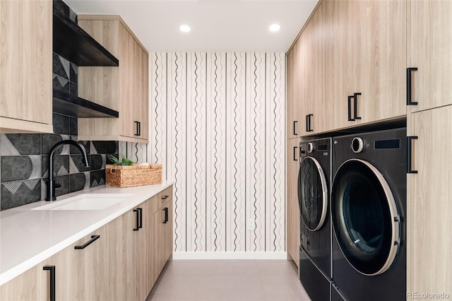 washroom with sink, cabinets, and independent washer and dryer