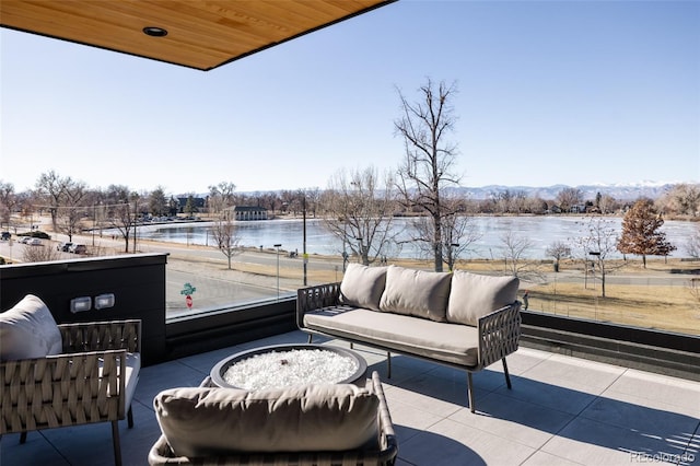 view of patio / terrace featuring a balcony, a water view, and outdoor lounge area