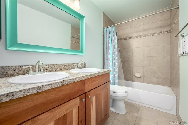 full bathroom with double vanity, toilet, tile patterned floors, and a sink