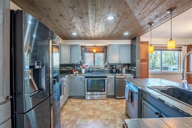 kitchen with wooden ceiling, a wealth of natural light, appliances with stainless steel finishes, and gray cabinets