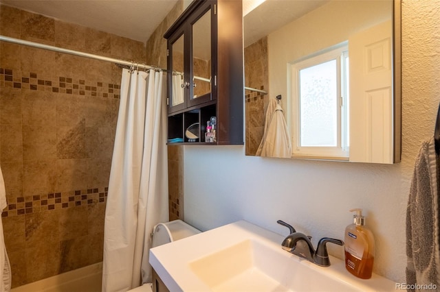 bathroom with a tile shower and vanity