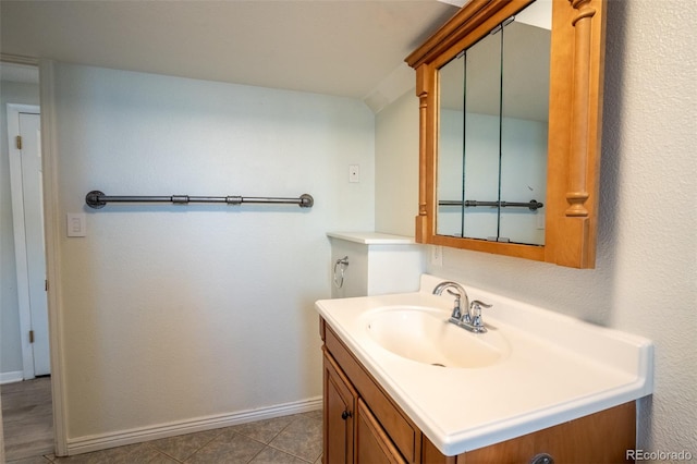 bathroom with tile patterned flooring, baseboards, and vanity