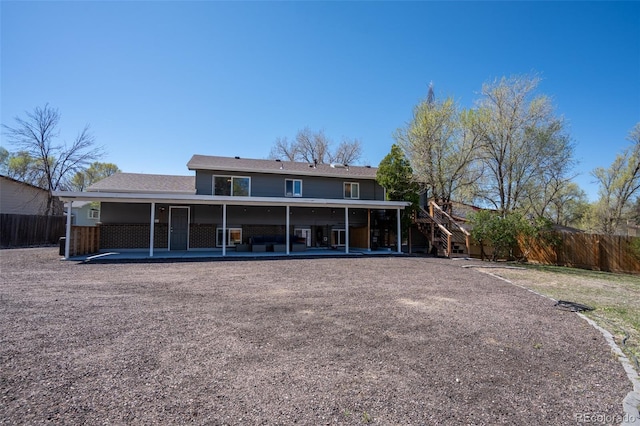 rear view of house with a fenced backyard, stairs, and a patio