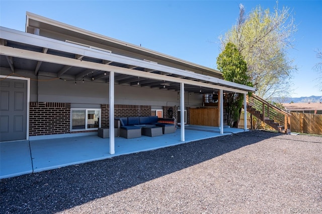 view of patio featuring outdoor lounge area, fence, stairway, and a mountain view