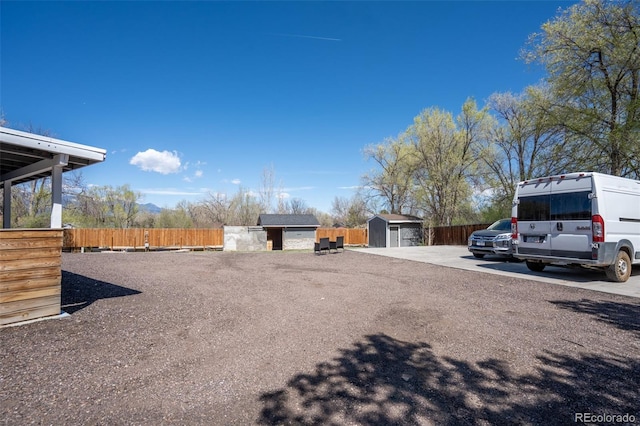 view of yard featuring an outdoor structure, fence, and a shed