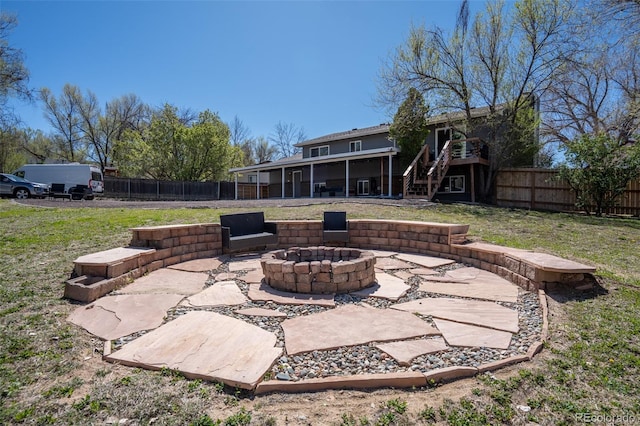 view of patio with a fenced backyard, a sunroom, a fire pit, and stairway