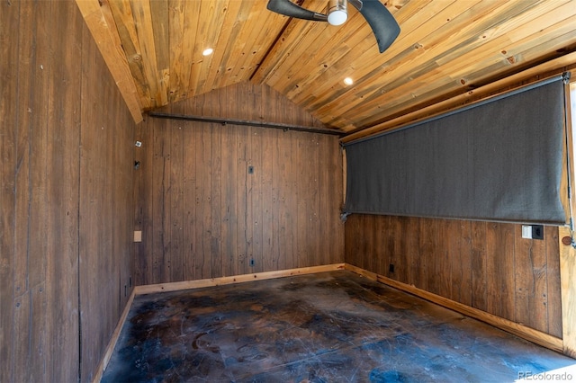 spare room featuring vaulted ceiling, wood walls, and baseboards