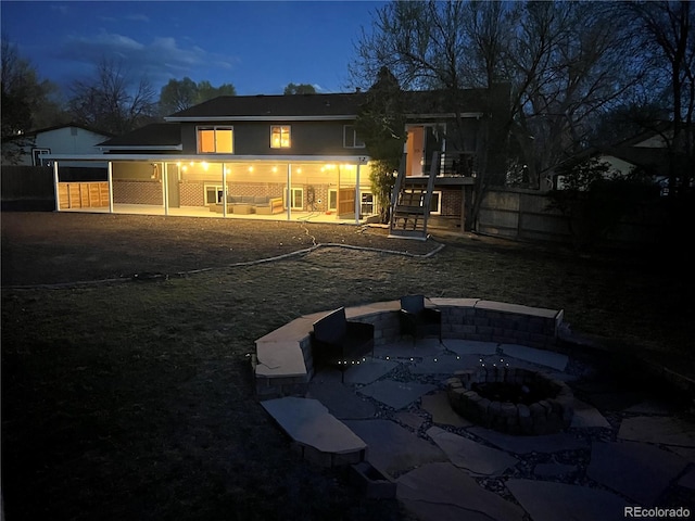 rear view of property featuring a fire pit, a patio area, and stairs