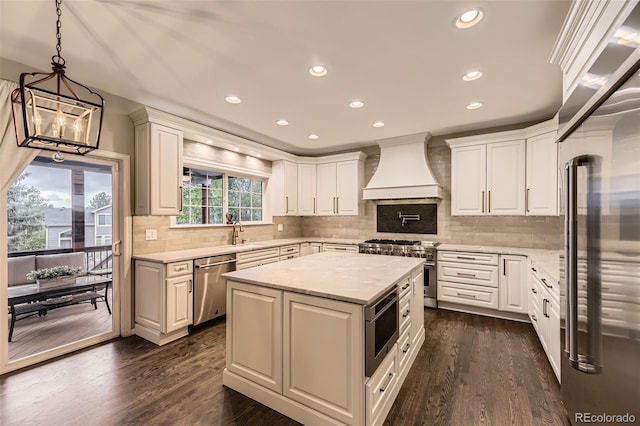 kitchen featuring high quality appliances, custom range hood, a sink, dark wood-style floors, and recessed lighting