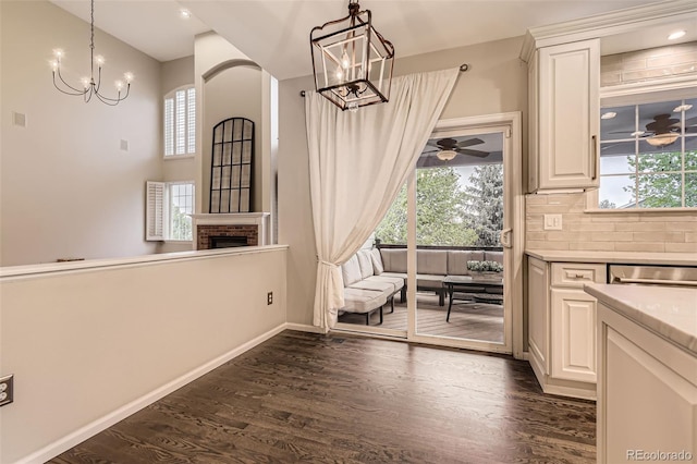 unfurnished dining area with plenty of natural light, a chandelier, and dark wood finished floors