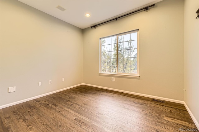 unfurnished room with dark wood-type flooring, baseboards, and recessed lighting