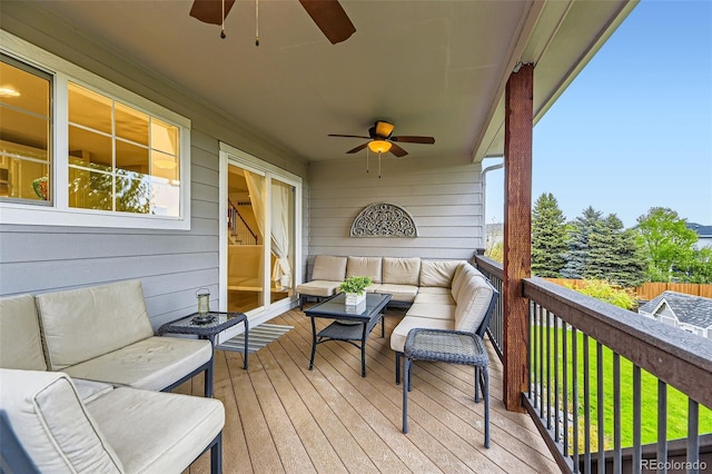 deck with a ceiling fan, an outdoor living space, and a lawn