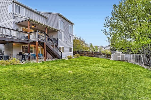 back of house featuring ceiling fan, a deck, stairway, a shed, and an outbuilding