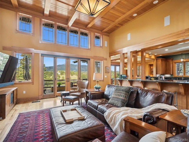 3395 Timbergate Trl, Evergreen, CO 80439 - living area with high vaulted ceiling, a wooden ceiling with exposed beams, light wood-style floors, plenty of natural light, and french doors