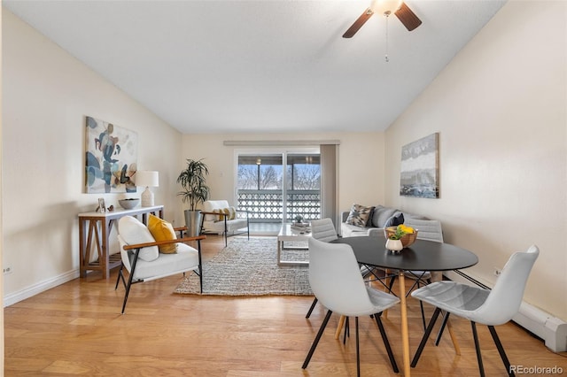 dining space featuring a baseboard radiator, lofted ceiling, ceiling fan, and light hardwood / wood-style flooring