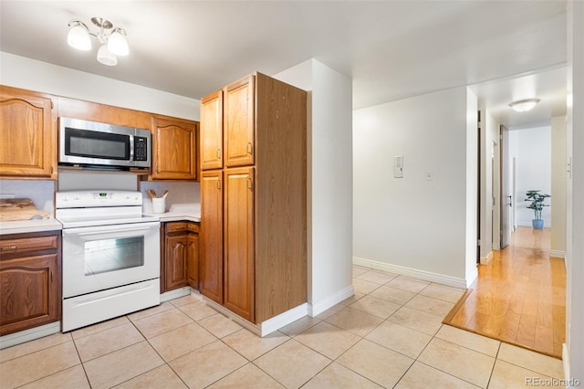 kitchen featuring light tile patterned floors and white electric stove