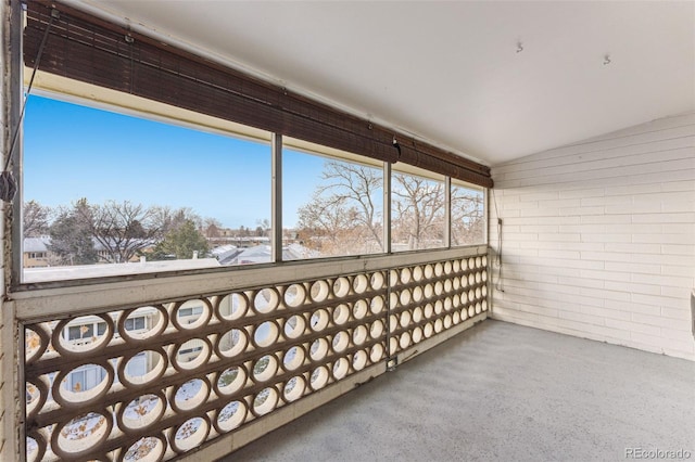 unfurnished sunroom featuring vaulted ceiling