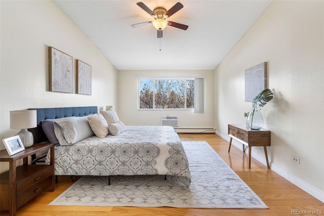 bedroom with baseboard heating, a wall unit AC, lofted ceiling, and light hardwood / wood-style flooring