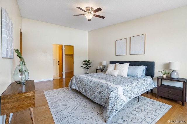 bedroom featuring hardwood / wood-style flooring, a spacious closet, and ceiling fan