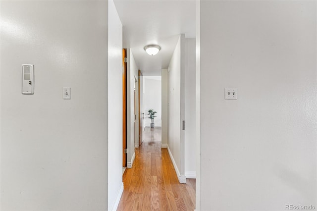 corridor with light hardwood / wood-style floors