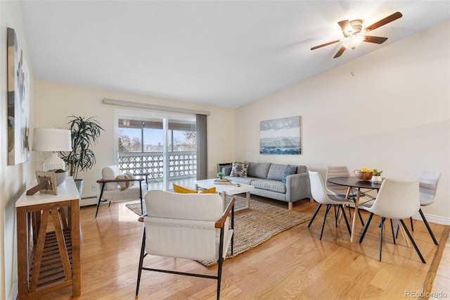 living room with ceiling fan, lofted ceiling, and light hardwood / wood-style flooring