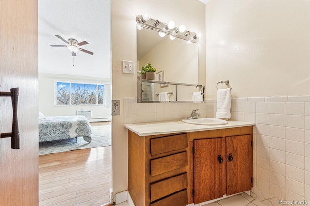 bathroom featuring ceiling fan, vanity, wood-type flooring, and tile walls