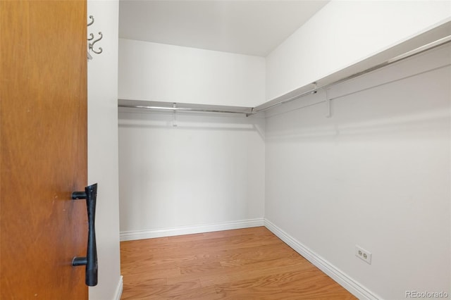 walk in closet with light hardwood / wood-style flooring