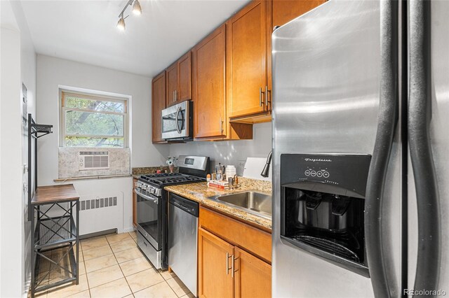 2100 N Franklin St Unit 5, Denver, CO 80205 - kitchen featuring appliances with stainless steel finishes, radiator heating unit, light tile patterned floors, and brown cabinets