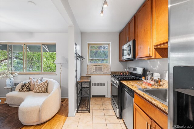 2100 N Franklin St Unit 5, Denver, CO 80205 - kitchen with stainless steel appliances, radiator heating unit, brown cabinets, light tile patterned floors, and light stone countertops