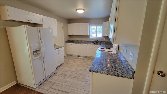 kitchen featuring white cabinetry, sink, dark stone countertops, and white appliances