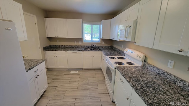 kitchen featuring sink, white appliances, dark stone counters, and white cabinets