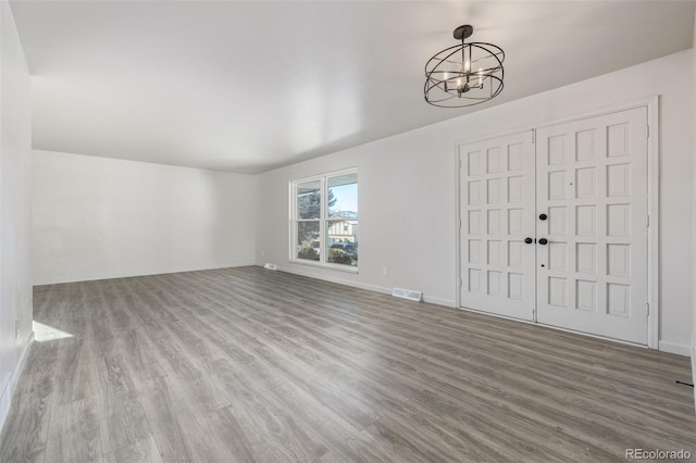 foyer entrance featuring a chandelier and wood-type flooring