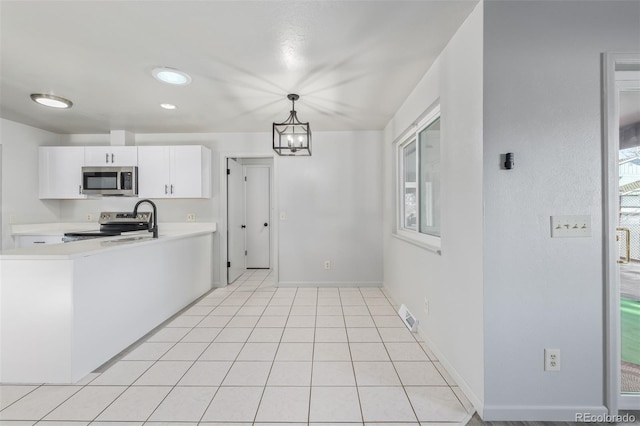 kitchen with decorative light fixtures, light tile patterned floors, a notable chandelier, white cabinetry, and stainless steel appliances