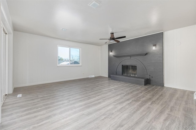 unfurnished living room featuring light hardwood / wood-style floors, a brick fireplace, and ceiling fan