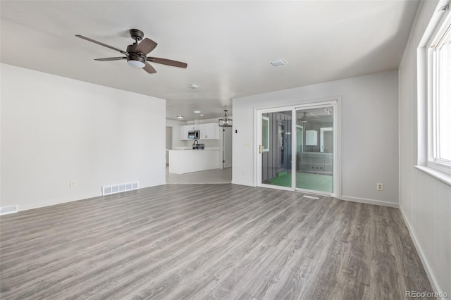 unfurnished living room featuring ceiling fan and light hardwood / wood-style floors