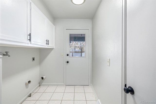 laundry area with hookup for an electric dryer, light tile patterned floors, and cabinets