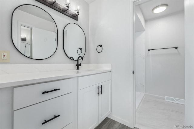 bathroom with vanity and a shower