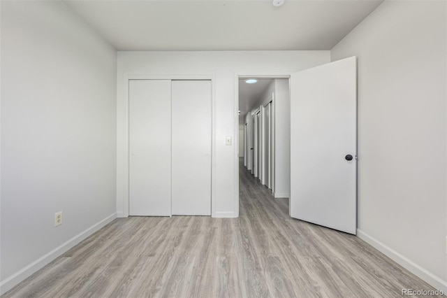 unfurnished bedroom featuring a closet and light wood-type flooring