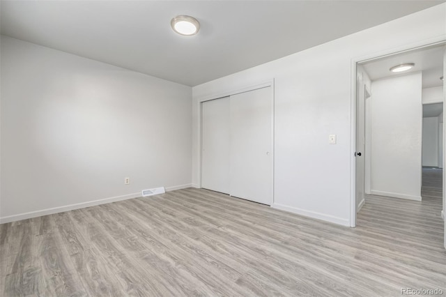 unfurnished bedroom with light hardwood / wood-style floors and a closet