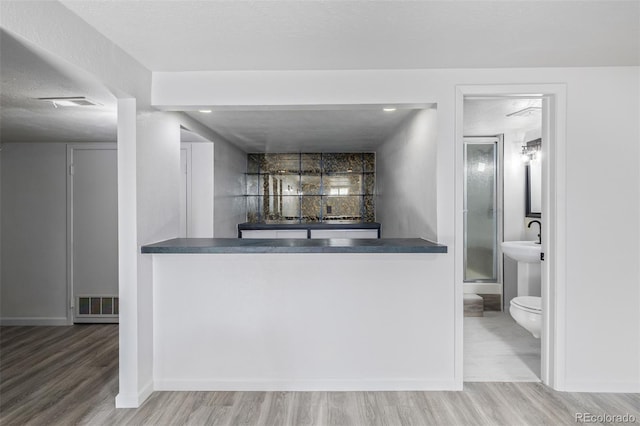 bar with wood-type flooring and a textured ceiling