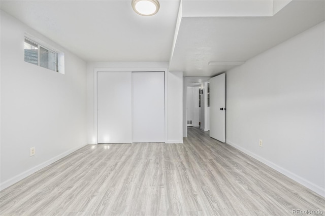 unfurnished bedroom featuring a closet and light hardwood / wood-style flooring