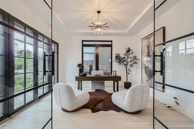 office with french doors, a tray ceiling, an inviting chandelier, and light wood-type flooring