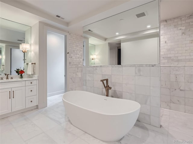 bathroom featuring vanity, independent shower and bath, and tile walls