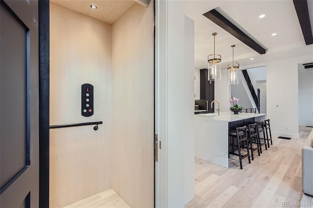 interior space featuring beamed ceiling, wood-type flooring, and elevator