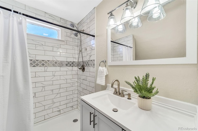 full bathroom with vanity and a tile shower